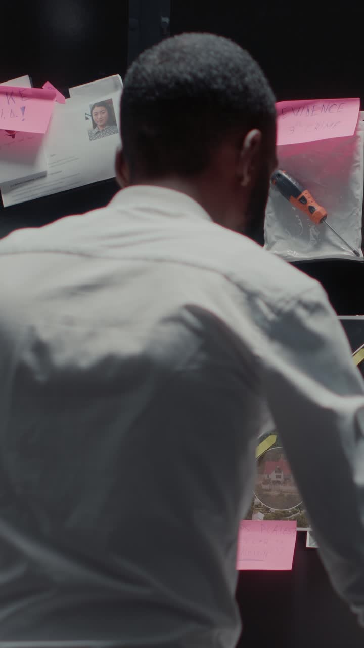 Vertical video: Male inspector analyzing evidence on board