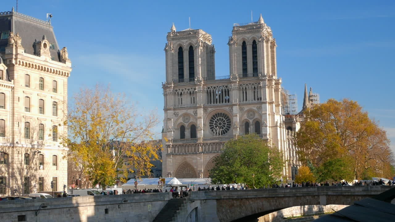 pan horizontal de la catedral de notre dame en parís en un hermoso día soleado de otoño desde el otro lado del río sena