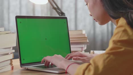 mujer trabajando en una computadora portátil con una pantalla verde