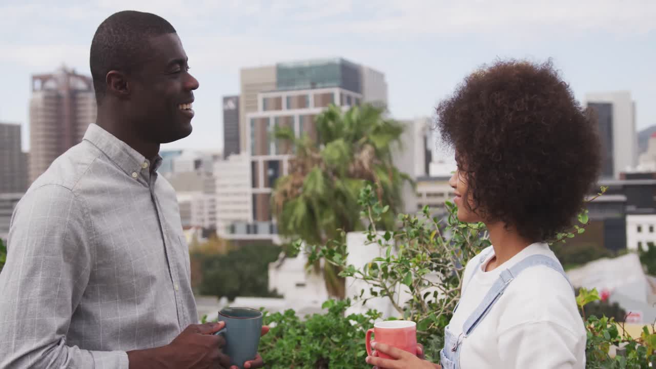 African man and mixed race woman discussing on rooftop