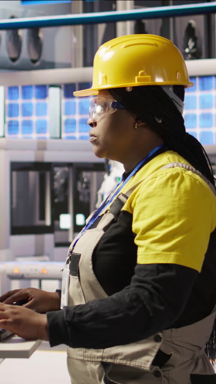 Vertical video Portrait of cheerful factory engineer typing on PC, monitoring production lines