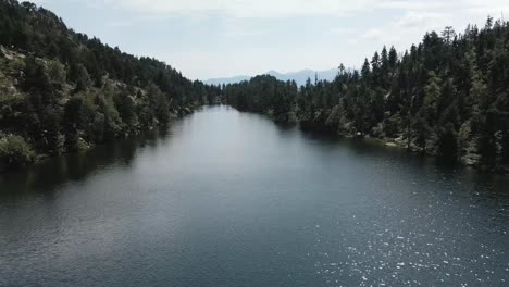 drone advancing through a big lake and descending to approach to the water, in la cerdanya, catalunya