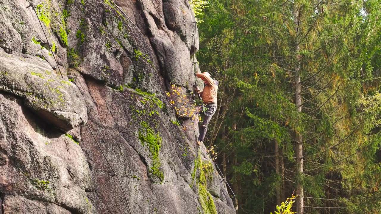 Mountain climber with safety equipment on steep cliff wall, Czech Republic