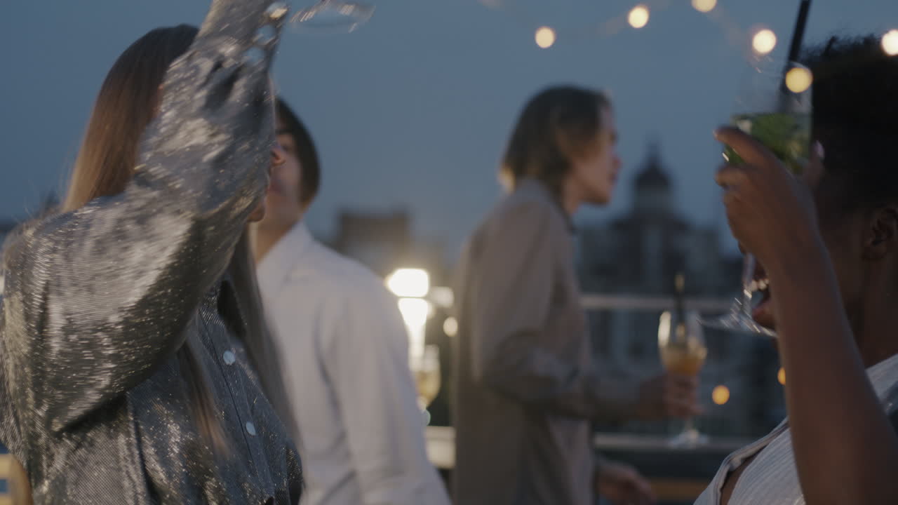 Friends Enjoying Drinks on Rooftop Terrace at Night