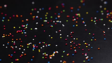 vibrant sprinkles cascade onto a dark background