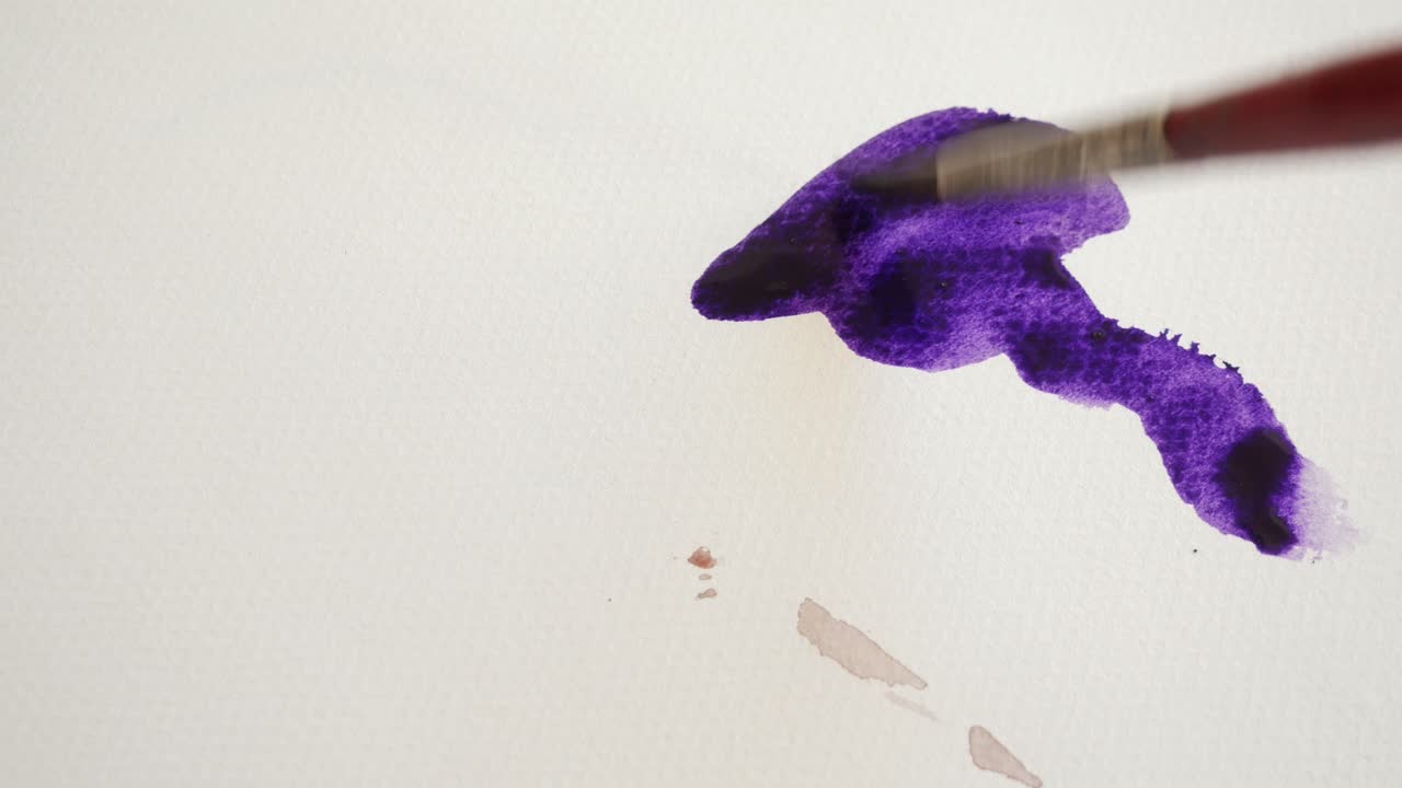 pincel extendiendo pintura de acuarela en papel blanco, de cerca