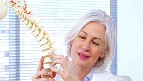 Portrait-of-female-doctor-holding-spine-model