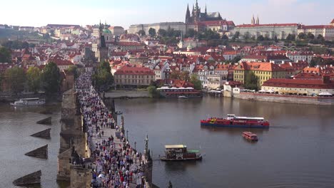 beautiful day establishing shot crowds crossing the charles bridge over the vltava river in prague czech republic 2