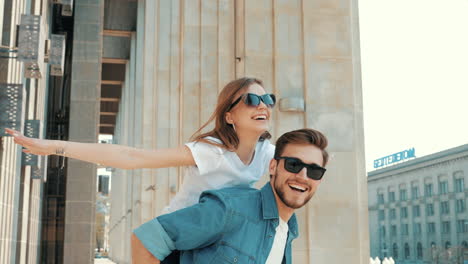 una pareja divirtiéndose montada en una mochila en la ciudad.