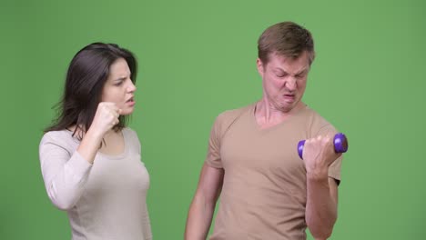 una pareja joven haciendo ejercicio juntos y animándose el uno al otro.