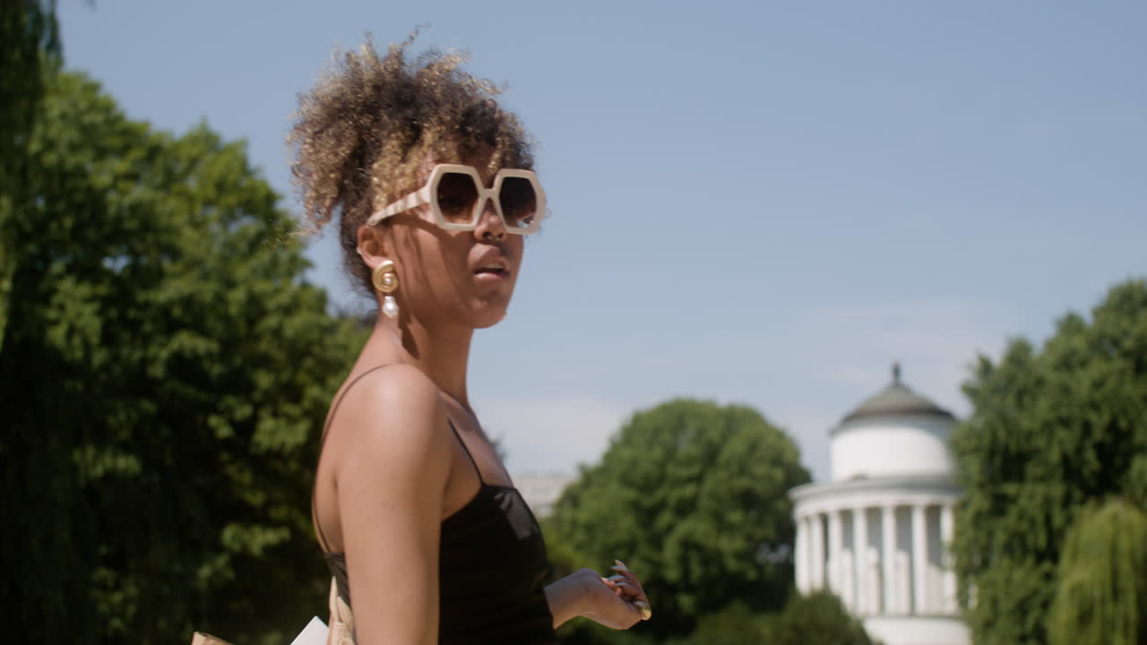 Side view of elegant african woman walking in the park