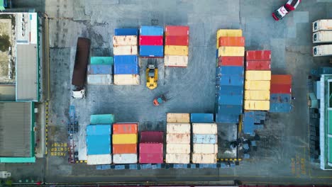 drone aerial view of palm oil kernel factory warehouse with cargo container and forklifts, at malaysia