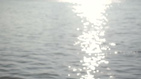 la superficie del río brilla bokeh el agua que fluye fuera de foco brilla en la tarde.4k