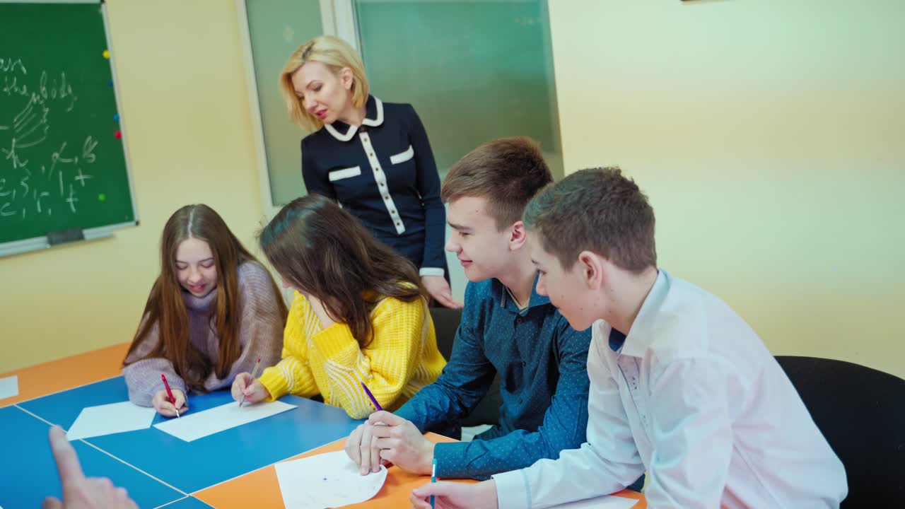 Children studying together at school. Teacher controls the study of students in the classroom. Middle school class. Back to school.