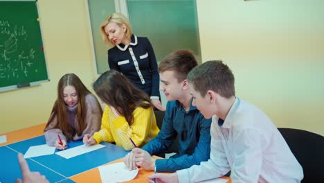 children studying together at school. teacher controls the study of students in the classroom. middle school class. back to school.