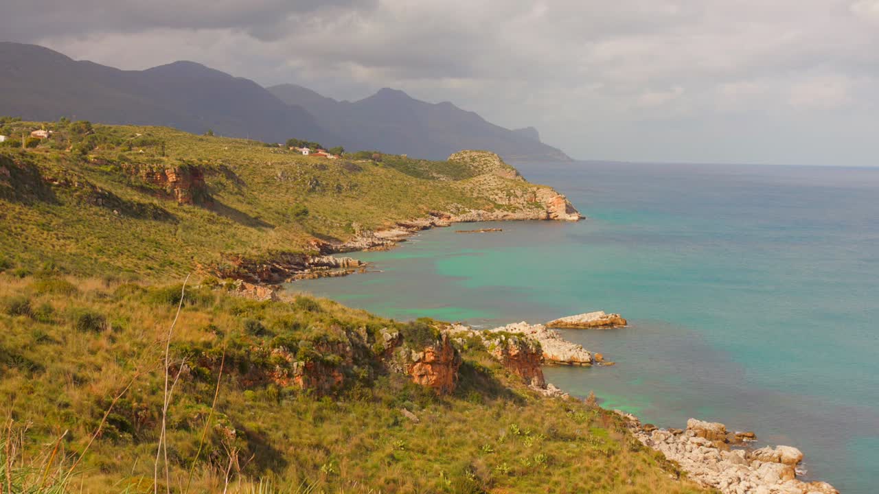 Serene coastal landscape in Sicily, with clear turquoise waters and rocky shores