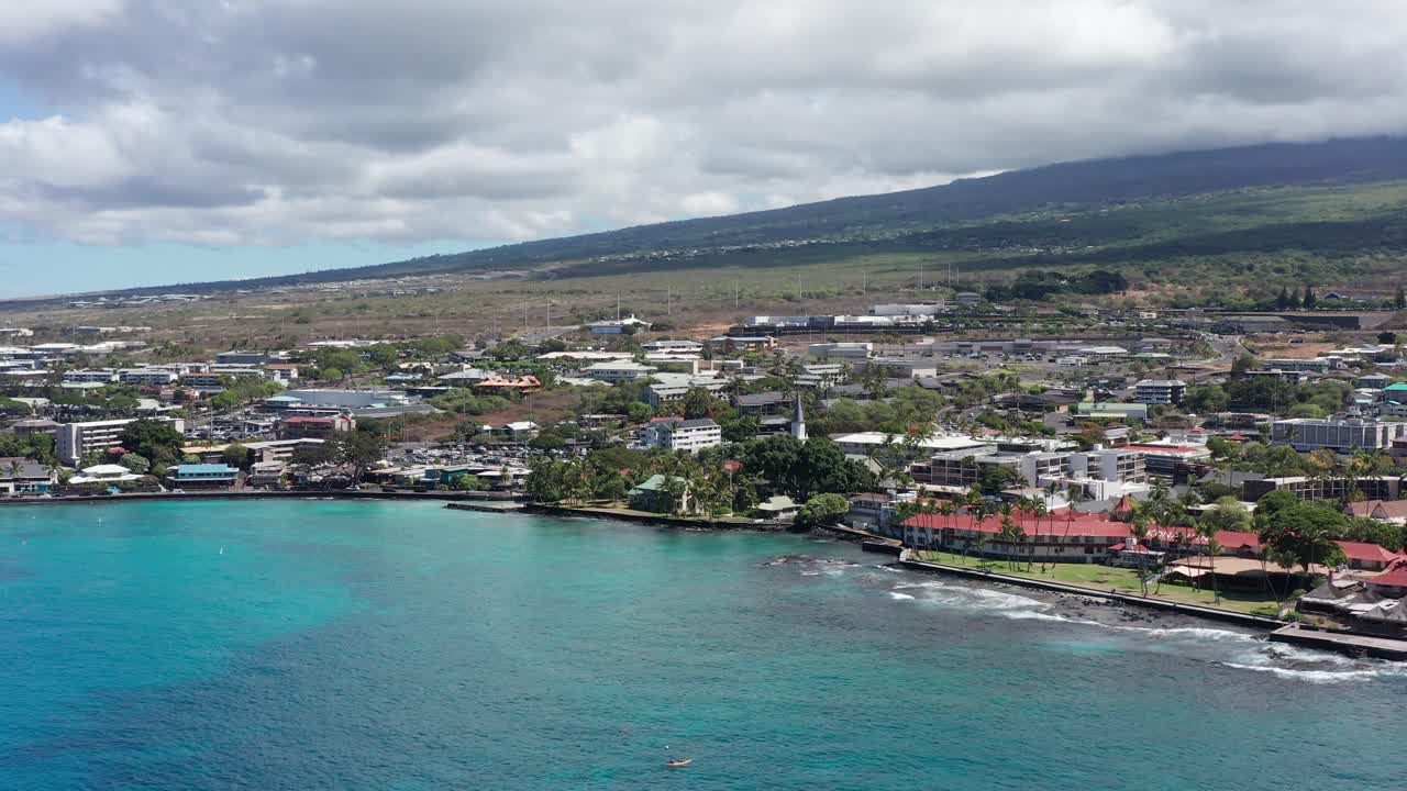 Aerial wide push-in shot of historic Hulihe'e Palace, vacation home of Hawaiian royalty, in Kailua-Kona on the Big Island of Hawai'i