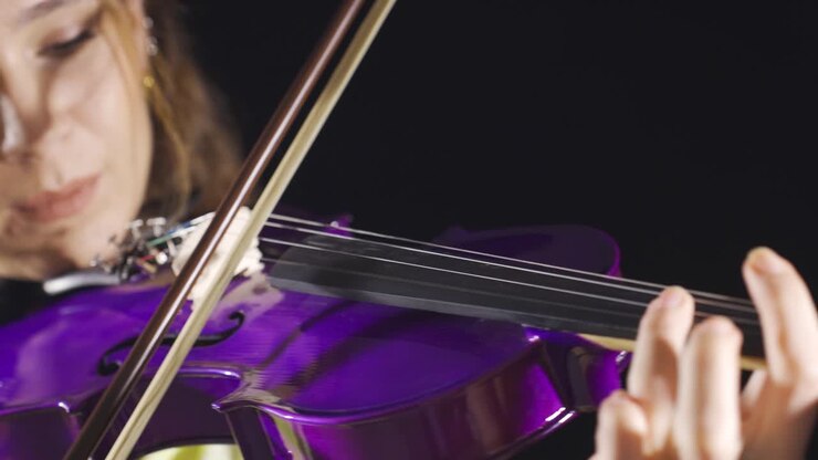 Violinist young woman playing her purple violin alone.