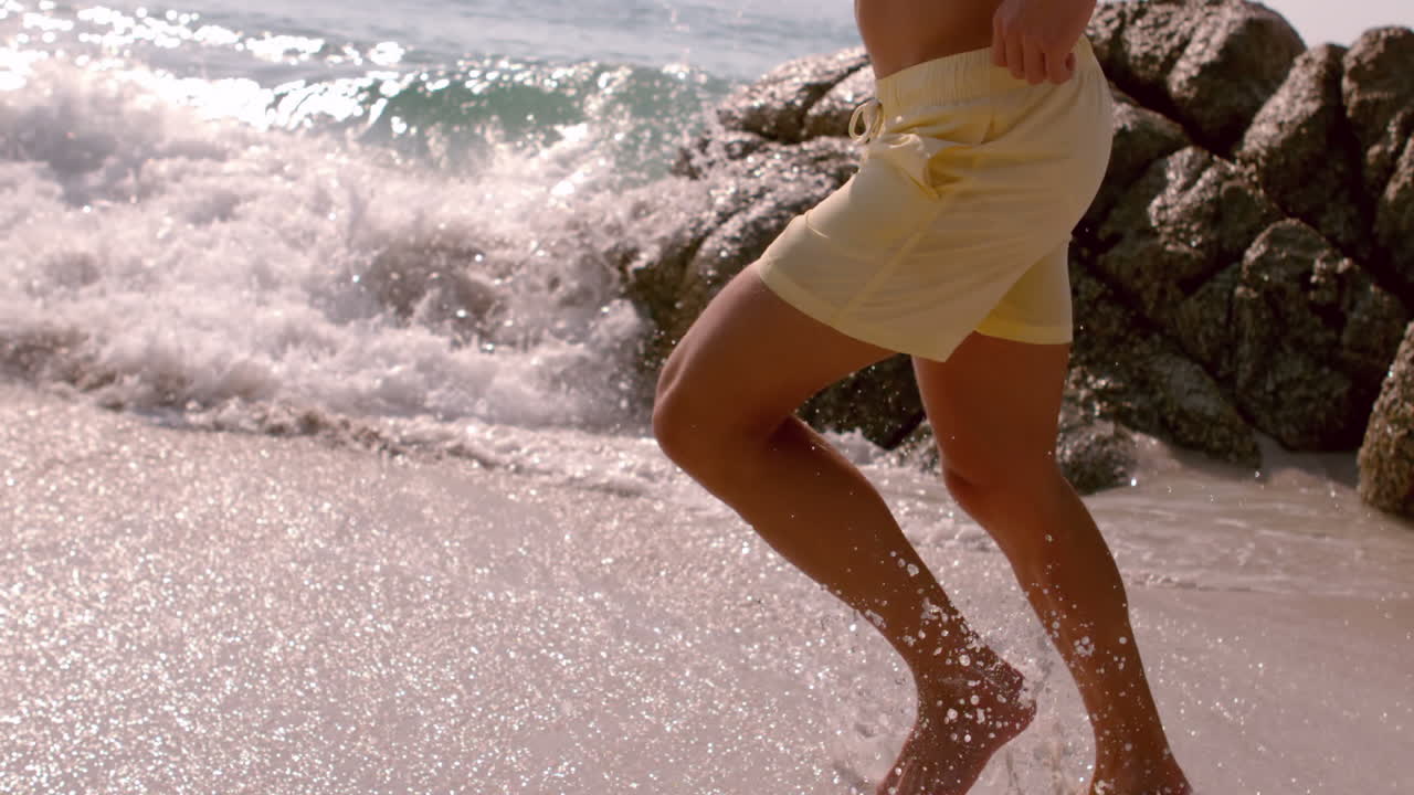 Uomo atletico che corre in mare