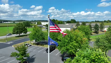 american flag waving against bright blue sky and green farmland in rural usa