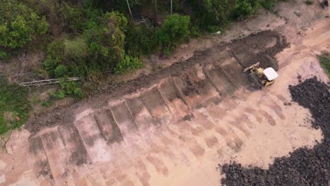 aerial view of a tractor and a grader to level the ground in the construction of a residential house