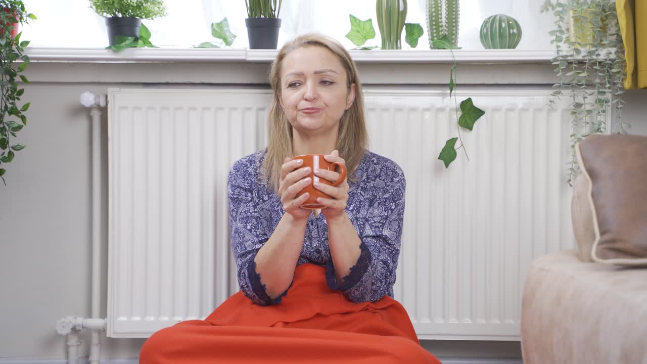 la mujer que consume una bebida caliente frente a la ventana toca el panal.