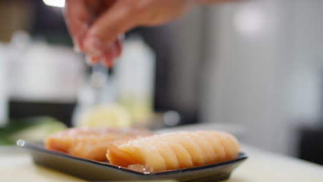 chef salting fresh salmon