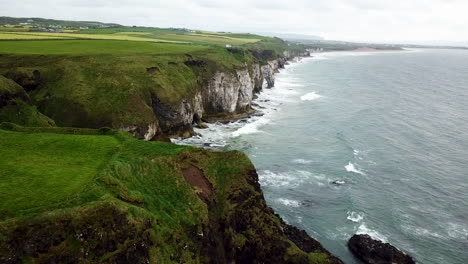 cinematic aerial view of coastline near dunluce castle