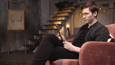 man using tablet in a cozy loft apartment