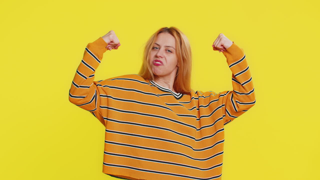 Donna felice che sembra sicura, che mostra i bicipi, che sente il potere, la forza di combattere per i diritti, il successo, la vittoria.