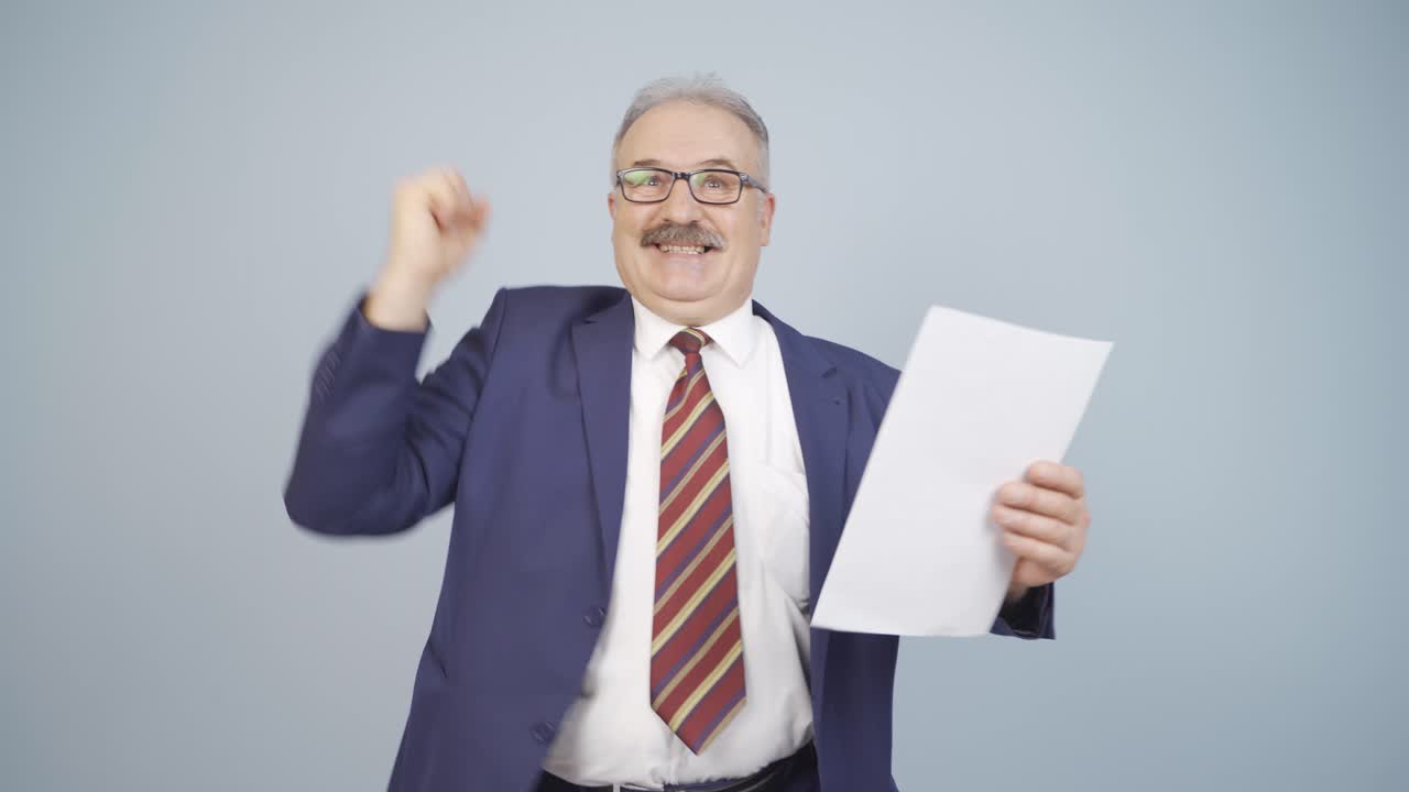el hombre de negocios mira el documento en su mano y se alegra.