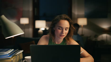 niña enfocada hablando computadora en un hogar acogedor. freelancer trabajando con computadora portátil horas extras