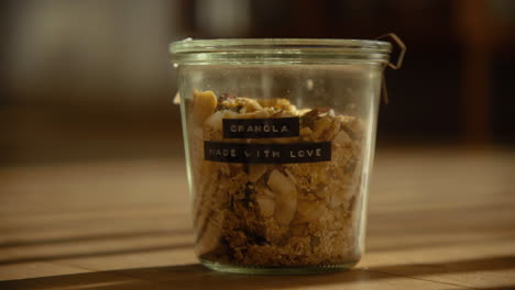 homemade granola in a glass container in sunlit living room