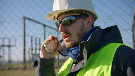 male engineer listening to the walkie talkie while nodding his head, handheld closeup