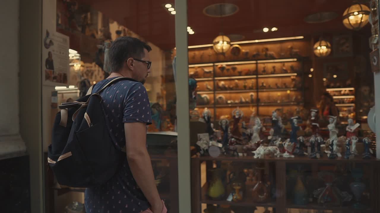 Uomo che guarda la vetrina di un negozio di souvenir