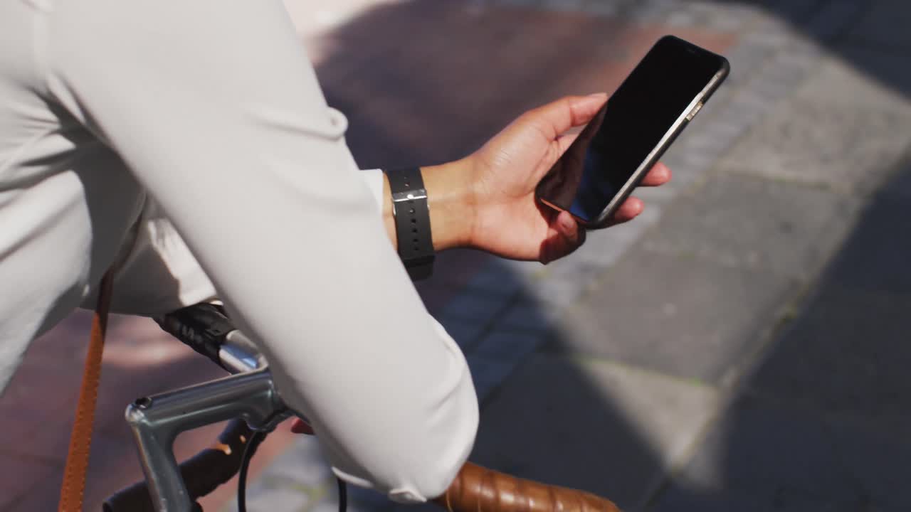 거리에서 자전거에 기대어 스마트폰을 사용하는 아프리카계 미국인 여성의 중간 섹션