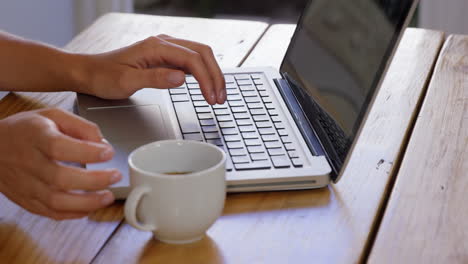 Cute-blonde-using-laptop-in-kitchen