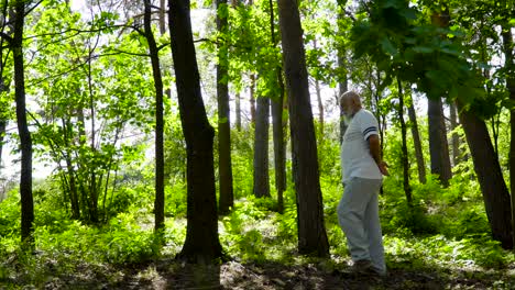 senior man leaning at tree trunk