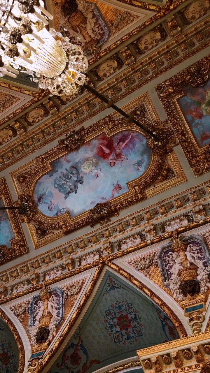 Boston, USA, 5 maggio 2025: Affresco classico sul soffitto con figure mitologiche e cornici dorate. Pittura barocca sul soffitto raffigurante figure in un cielo blu circondate da intricate modanature in foglia d'oro.