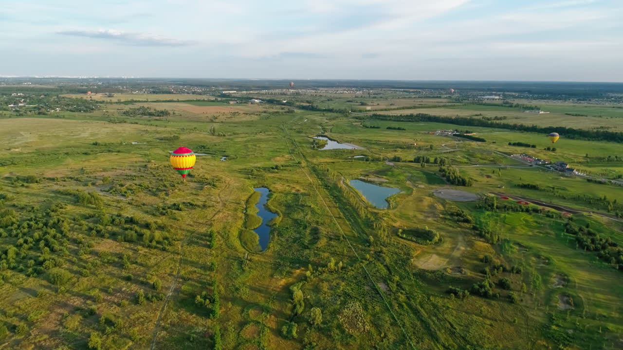 Colorful hot air balloon. Aerial view of air balloon over fields