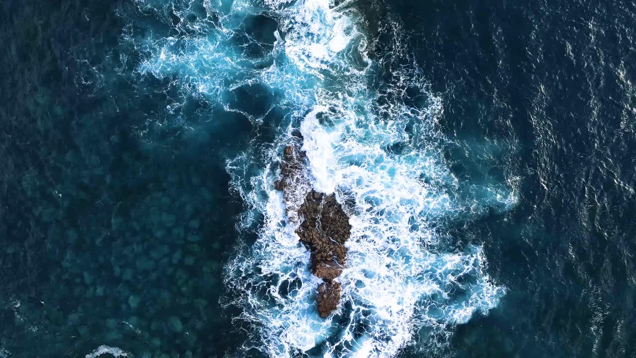 Pohled shora na vlny tříštící se o mořskou skálu, Madeira, Portugalsko.