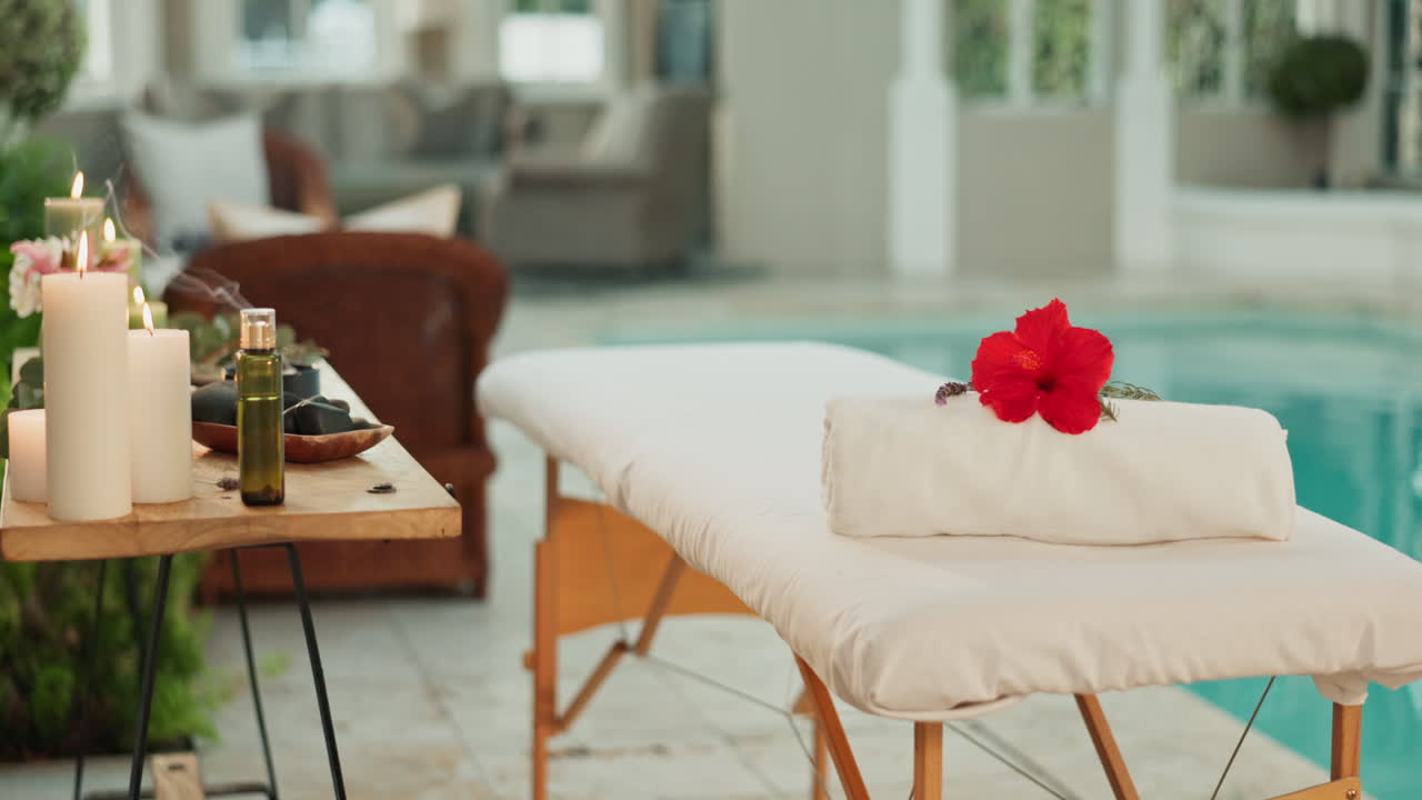 Spa massage setup with hibiscus flower and candles