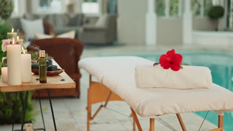 spa massage setup with hibiscus flower and candles
