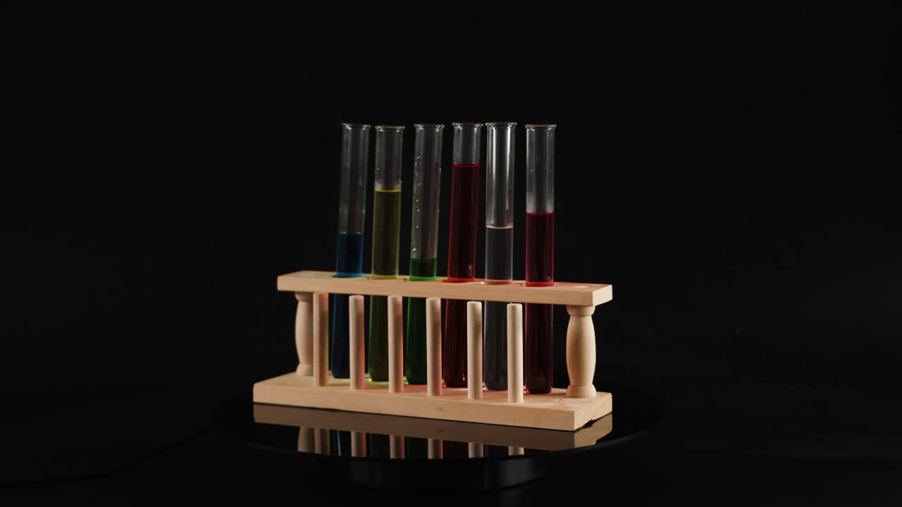 tubos de ensayo con líquidos coloreados en un estante de madera
