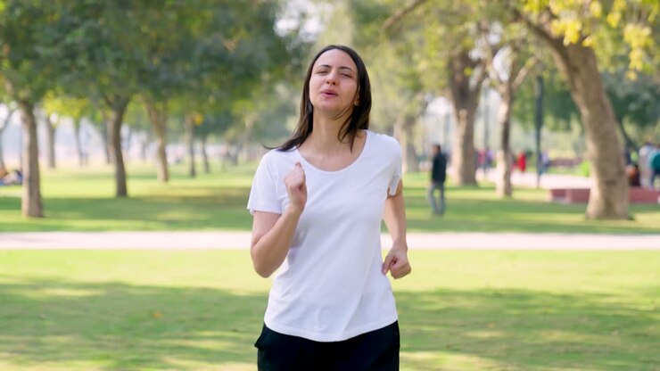 chica india corriendo en el mismo lugar y haciendo ejercicio en un parque por la mañana