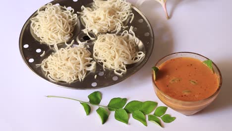 Noolappam-Idiyappam-rice-noodles,-a-popular-traditional-steam-cooked-Kerala-breakfast-dish-with-hot-spicy-black-bengal-gram-curry-on-houseboat,-Alleppey,-India