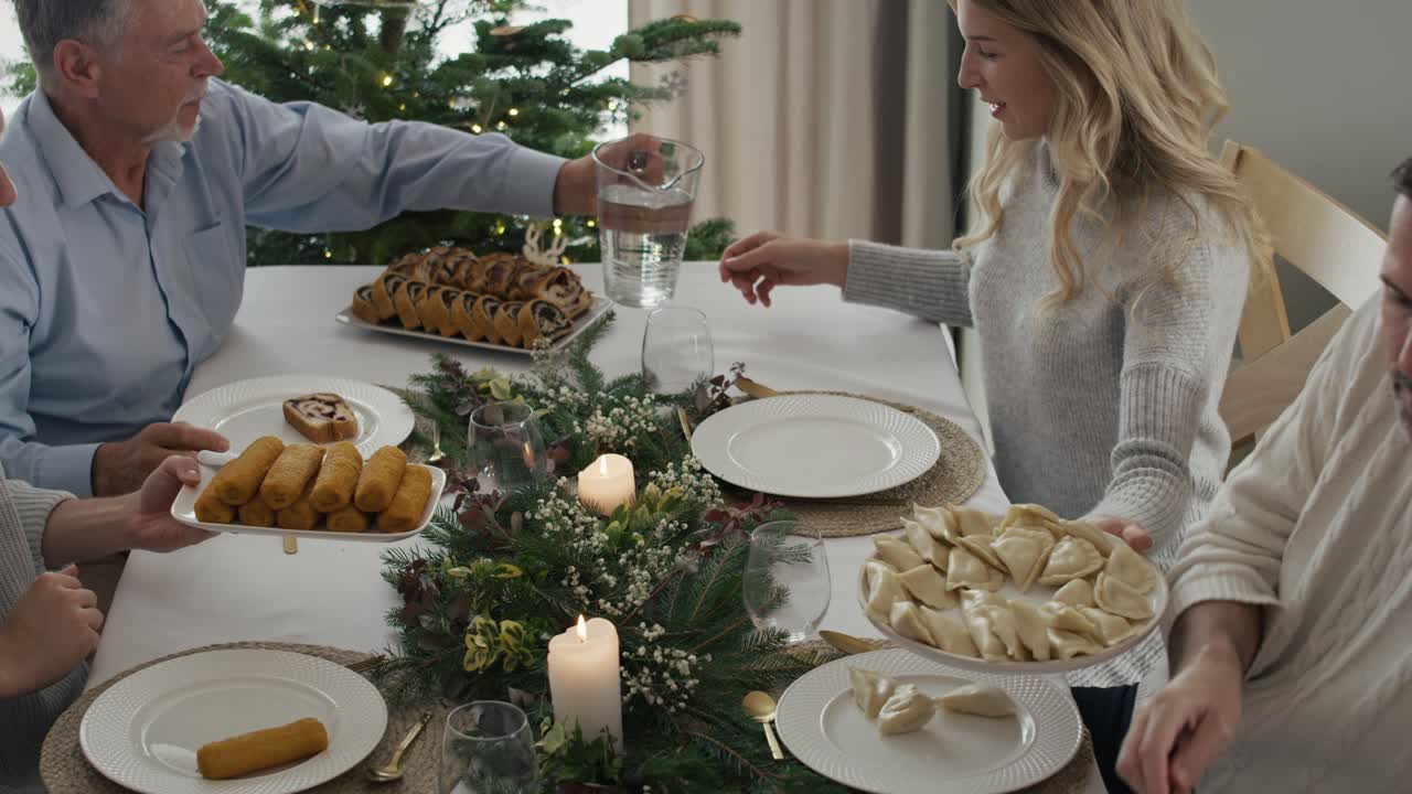 gran familia caucásica compartiendo una comida durante la víspera de navidad.