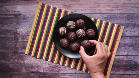 hand pick dark chocolate on a plate , top view
