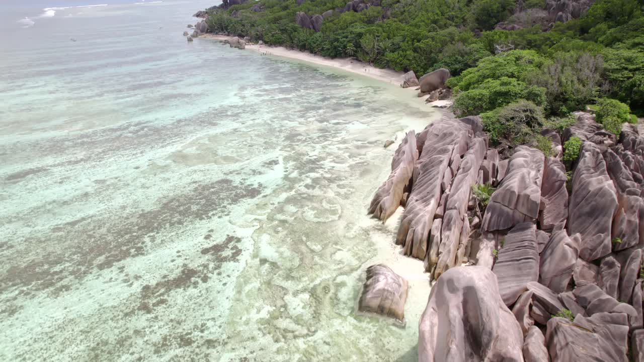 Riprese drone di una spettacolare spiaggia con bassa marea e pietre di granito di Anse Source d'Argent, La Digue, Seychelles 004 30fps