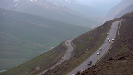 foggy view of the babusar valley, mountain pass in pakistan, street with passing cars, static, copy space